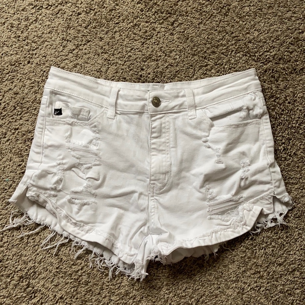 white denim jeans with tears. the tears higher up, are covered with material!